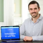 Medarbejder viser Lets Talk-velkomstskærm på bærbar computer